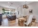 Open-concept dining area with a rustic wood table, cushioned chairs, and view to the kitchen island at 12193 W 51St Ave, Wheat Ridge, CO 80033