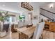 Well-lit dining area features a rustic wooden table and upholstered chairs next to stairs and living room at 12193 W 51St Ave, Wheat Ridge, CO 80033