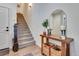 An inviting entryway featuring a wooden console table, decorative mirror, and staircase, providing a warm welcome at 12193 W 51St Ave, Wheat Ridge, CO 80033