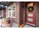 A charming red brick porch featuring a holiday wreath, rocking chair, and a welcoming entrance at 12193 W 51St Ave, Wheat Ridge, CO 80033