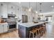 Modern kitchen with white cabinetry, stainless steel appliances, and a large island open to the living area at 12193 W 51St Ave, Wheat Ridge, CO 80033