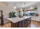 Kitchen island with white countertop and dark cabinets, complemented by pendant lights and greenery at 12193 W 51St Ave, Wheat Ridge, CO 80033