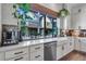 Bright kitchen with white cabinets, stainless steel appliances, and a large window overlooking the neighborhood at 12193 W 51St Ave, Wheat Ridge, CO 80033