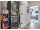 A laundry room featuring a stacked washer and dryer with an adjacent doorway to a living area at 12193 W 51St Ave, Wheat Ridge, CO 80033