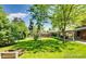 Expansive backyard features lush lawn, mature trees, and covered patio for outdoor relaxation at 7005 S Ash Cir, Centennial, CO 80122