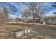 Spacious backyard with covered patio, mature trees, and detached garage at 7005 S Ash Cir, Centennial, CO 80122