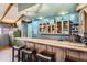 Custom bar with oak cabinets, tile countertop, and seating for entertaining guests at 7005 S Ash Cir, Centennial, CO 80122