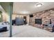 Finished basement with brick fireplace, entertainment area, and carpeted flooring at 7005 S Ash Cir, Centennial, CO 80122