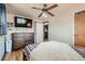 Simple bedroom with a wood dresser, carpeted floor, ceiling fan and a large TV at 7005 S Ash Cir, Centennial, CO 80122