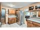 Traditional kitchen featuring wooden cabinets, stainless steel fridge, and an open view to the living room at 7005 S Ash Cir, Centennial, CO 80122