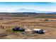 Aerial view of house, barn, and expansive land with mountain backdrop at 26100 County Road 5, Elizabeth, CO 80107