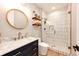 Bright bathroom features a glass-enclosed shower with white and gold tiling, marble countertop, and gold fixtures at 26100 County Road 5, Elizabeth, CO 80107