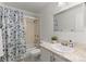 Bright bathroom features a tub with shower, white vanity, and large mirror at 7700 W Glasgow Pl # 8C, Littleton, CO 80128