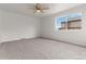 Inviting bedroom featuring neutral carpet, a ceiling fan, and a large window offering pleasant natural light at 7700 W Glasgow Pl # C, Littleton, CO 80128