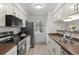 Well-lit kitchen features white cabinetry, stainless steel appliances, and a breakfast bar, with tile flooring at 7700 W Glasgow Pl # 8C, Littleton, CO 80128