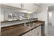 Close-up view of the kitchen's stainless steel sink and breakfast bar, connecting to the living space at 7700 W Glasgow Pl # C, Littleton, CO 80128