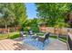 Cozy back deck with outdoor seating surrounded by a lush green backyard and wooden fence at 2629 Wisteria Dr, Erie, CO 80516