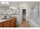 Well-lit bathroom featuring a vanity with double mirrors, a soaking tub, and a separate walk-in shower at 2629 Wisteria Dr, Erie, CO 80516