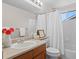 Bright bathroom with a single sink vanity and shower with white tile and shower curtain at 2629 Wisteria Dr, Erie, CO 80516