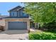 Charming two-story home features a stone facade, gray siding, a two-car garage and a well-manicured lawn at 2629 Wisteria Dr, Erie, CO 80516