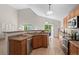 Well-lit kitchen with wood cabinetry, stainless steel appliances, and a breakfast bar overlooking the dining area at 2629 Wisteria Dr, Erie, CO 80516