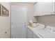 Laundry room featuring a white washer and dryer, cabinets, and a stylish laundry-themed sign at 2629 Wisteria Dr, Erie, CO 80516