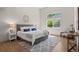 Bright main bedroom with a large window, stylish furniture, a gray rug, and light-colored walls and hardwood flooring at 2629 Wisteria Dr, Erie, CO 80516