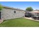 Spacious backyard with a patio, artificial grass, and well-maintained gray brick exterior at 2945 E 26Th Avenue Pkwy, Denver, CO 80205