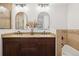 Double sink bathroom vanity features granite countertops, wood cabinets, and arched mirrors at 2945 E 26Th Avenue Pkwy, Denver, CO 80205