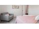 Cozy bedroom with a soft gray armchair, light pink bedding and neutral decor at 2945 E 26Th Avenue Pkwy, Denver, CO 80205