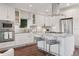 Bright kitchen with white cabinets, stainless appliances, center island with seating, and stylish backsplash at 2945 E 26Th Avenue Pkwy, Denver, CO 80205