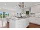 Modern kitchen island with a cooktop, white cabinets, and a view of the spacious living area at 2945 E 26Th Avenue Pkwy, Denver, CO 80205