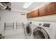 Modern laundry room with front loading washer/dryer, and storage cabinets at 2945 E 26Th Avenue Pkwy, Denver, CO 80205