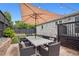 Outdoor patio with dining set under a large umbrella, surrounded by a brick wall and lush greenery at 2945 E 26Th Avenue Pkwy, Denver, CO 80205