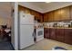 Small kitchen with dark wood cabinets and white appliances at 6495 E Happy Canyon Rd # 88, Denver, CO 80237