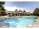 Community pool with brick building and lounge chairs at 6495 E Happy Canyon Rd # 88, Denver, CO 80237