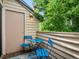 Outdoor balcony features blue chairs, table, and a view of mature trees at 7379 S Gore Range Rd # 304, Littleton, CO 80127