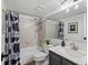 Bathroom with a shower-tub combo, modern black and white shower curtain, and neutral tile at 7379 S Gore Range Rd # 304, Littleton, CO 80127