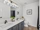 Modern bathroom featuring double sinks, vanity lighting, and neutral tile flooring at 7379 S Gore Range Rd # 304, Littleton, CO 80127