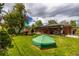 Spacious backyard with a covered patio, a playset, and mature trees that are ideal for outdoor living at 428 W Valleyview Ave, Littleton, CO 80120