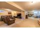 Finished basement area featuring plush carpeting, neutral walls, a large leather sofa, and a flat-screen TV at 428 W Valleyview Ave, Littleton, CO 80120