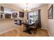 Dining area with hardwood floors, wooden table set, chandelier, and window with backyard view at 428 W Valleyview Ave, Littleton, CO 80120