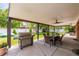 An outdoor patio with a barbecue grill, table and chairs, and a ceiling fan at 428 W Valleyview Ave, Littleton, CO 80120