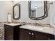 Bathroom with double vanity, granite countertop, and decorative mirrors at 6150 S Fulton St, Englewood, CO 80111