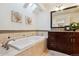 Relaxing bathroom with soaking tub, double sink vanity, and skylight at 6150 S Fulton St, Englewood, CO 80111