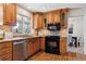 Kitchen with wood cabinets, granite counters, and stainless steel appliances at 6150 S Fulton St, Englewood, CO 80111