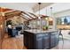 Spacious kitchen with an island, wood beams, and stone fireplace at 6150 S Fulton St, Englewood, CO 80111