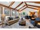 Living room with vaulted ceiling, exposed beams, and a stone fireplace at 6150 S Fulton St, Englewood, CO 80111