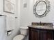 Elegant powder room with dark wood vanity, granite countertop, and decorative mirror at 6150 S Fulton St, Englewood, CO 80111