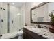 Modern bathroom featuring a granite vanity, a glass-enclosed shower with bench seating, and neutral tones at 2730 Fox View Trl, Franktown, CO 80116